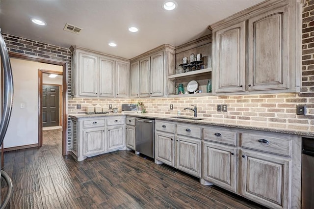 kitchen featuring tasteful backsplash, visible vents, a sink, light stone countertops, and dishwasher