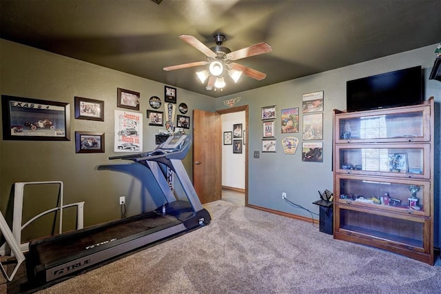 exercise room with carpet, a ceiling fan, and baseboards