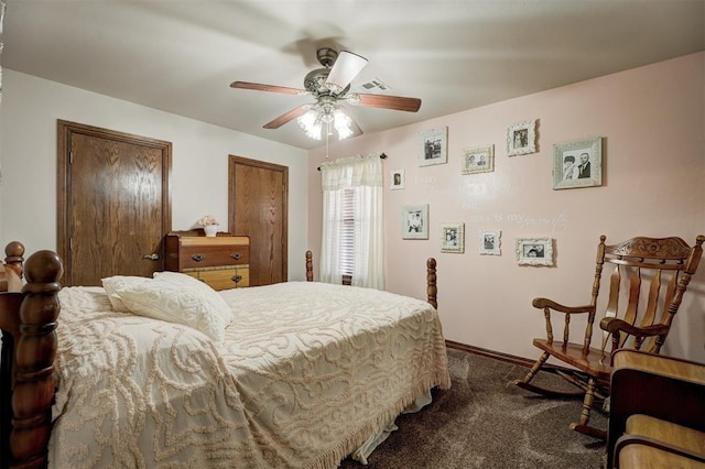 bedroom featuring multiple closets, dark colored carpet, visible vents, and ceiling fan