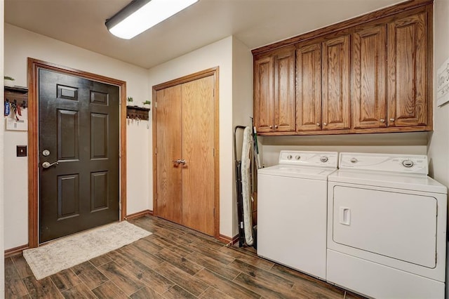 clothes washing area featuring cabinet space, wood tiled floor, baseboards, and separate washer and dryer