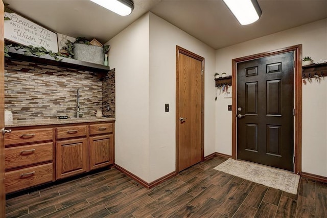 kitchen with brown cabinets, open shelves, backsplash, and wood tiled floor