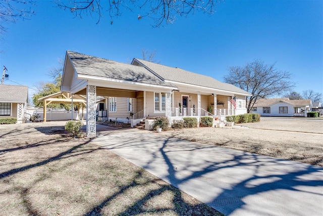 view of front of house featuring driveway, covered porch, a shingled roof, and a carport