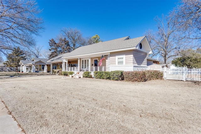 view of front facade featuring covered porch and fence