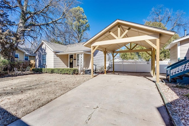 view of front of home featuring a carport, fence, driveway, and a shingled roof