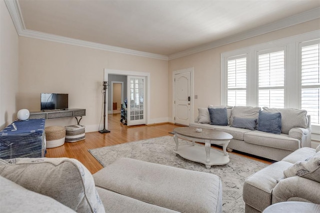 living room with baseboards, ornamental molding, and wood finished floors