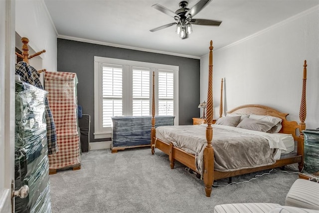 carpeted bedroom with ornamental molding and a ceiling fan