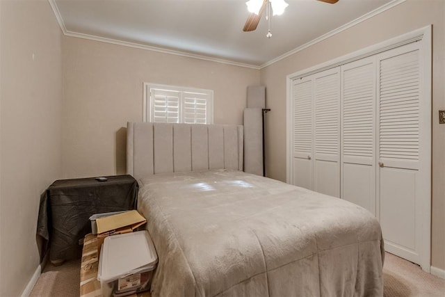 carpeted bedroom featuring a closet, crown molding, baseboards, and ceiling fan