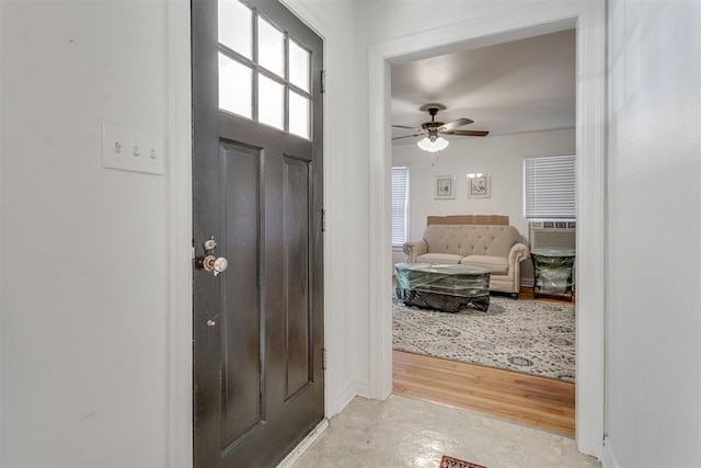 foyer entrance featuring concrete flooring, cooling unit, and a ceiling fan