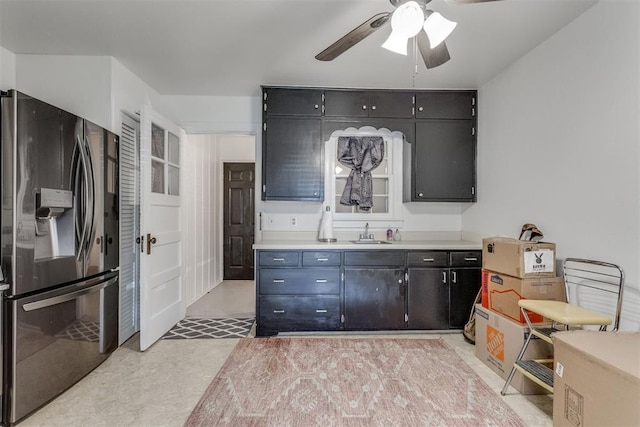 kitchen with light countertops, stainless steel refrigerator with ice dispenser, a sink, and a ceiling fan