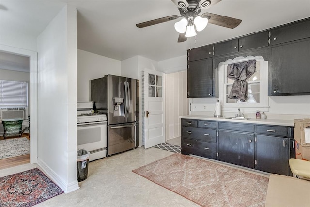 kitchen with white gas range oven, light countertops, light floors, stainless steel refrigerator with ice dispenser, and a sink