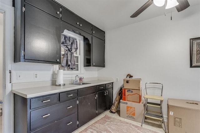 kitchen with a ceiling fan, light countertops, and a sink