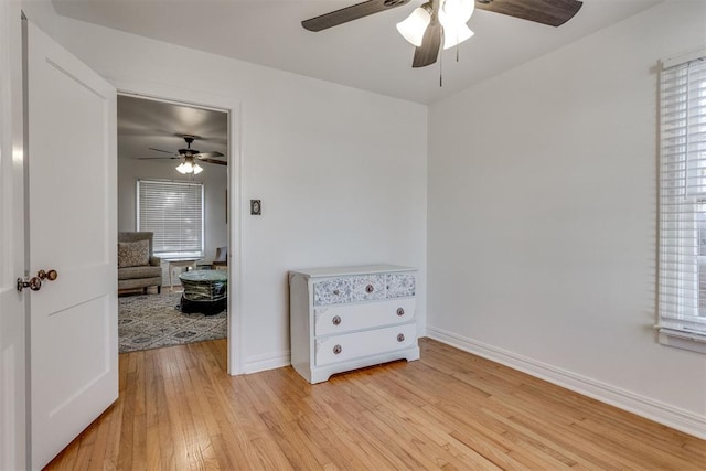 bedroom featuring light wood-style flooring, baseboards, and a ceiling fan