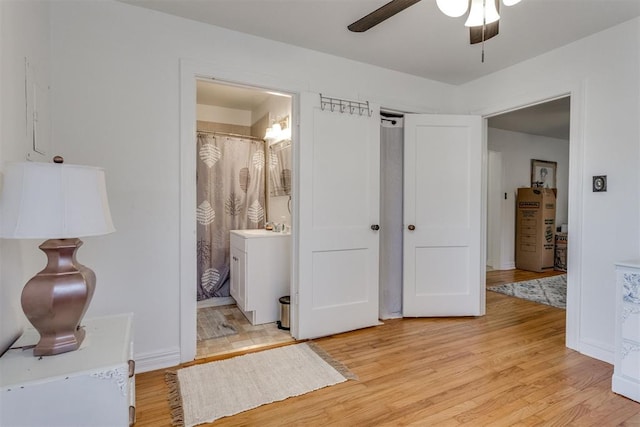 bedroom with a sink, ensuite bath, and light wood finished floors