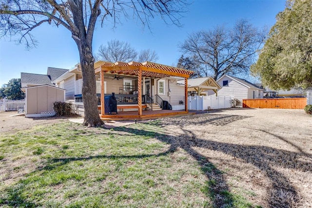 back of property featuring a lawn, fence, a deck, and a pergola