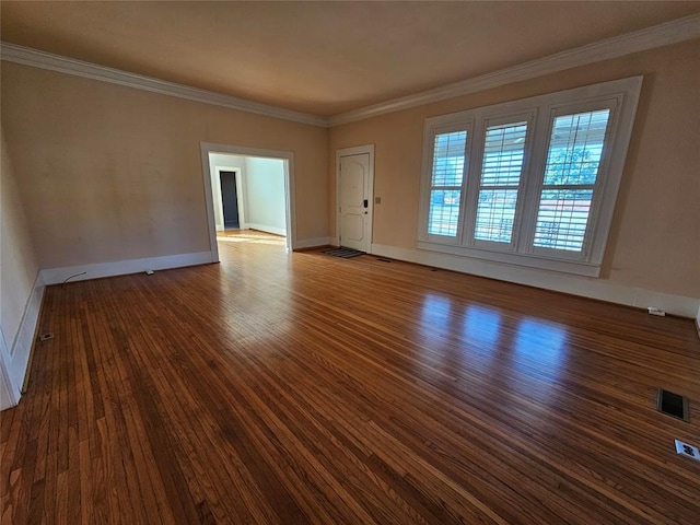 804 N Willow St, Pauls Valley, OK 73075 - spare room featuring baseboards, ornamental molding, visible vents, and wood finished floors
