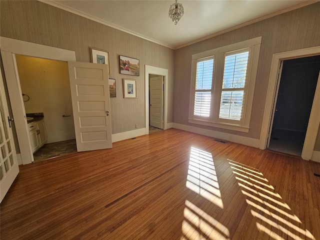 804 N Willow St, Pauls Valley, OK 73075 - empty room with wallpapered walls, ornamental molding, baseboards, and wood finished floors