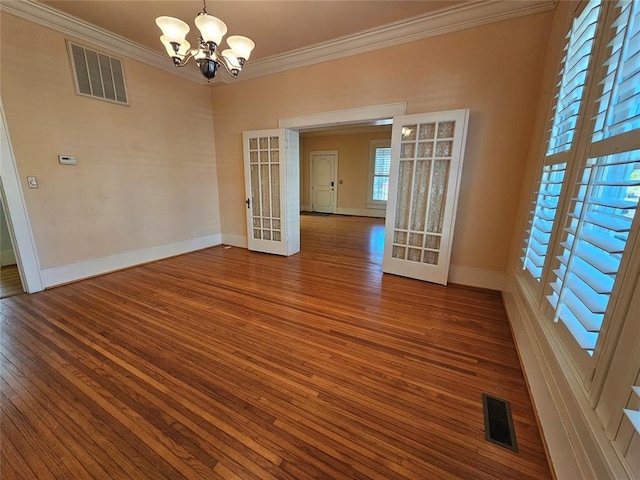 804 N Willow St, Pauls Valley, OK 73075 - empty room with ornamental molding, visible vents, a notable chandelier, and wood finished floors