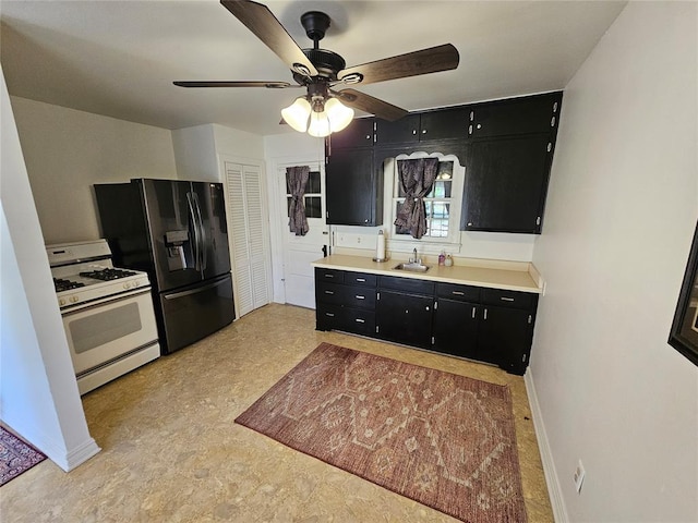 804 N Willow St, Pauls Valley, OK 73075 - kitchen with a ceiling fan, white range with gas cooktop, a sink, dark cabinets, and black refrigerator with ice dispenser