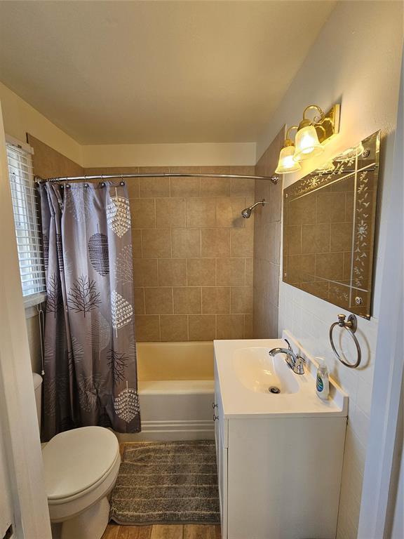 804 N Willow St, Pauls Valley, OK 73075 - bathroom featuring toilet, vanity, shower / bath combo with shower curtain, and wood finished floors