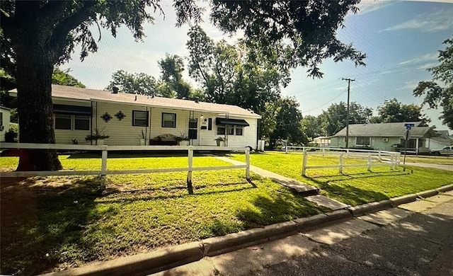 view of front facade featuring fence and a front lawn