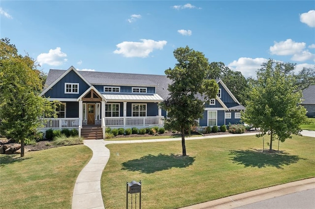 craftsman-style home featuring board and batten siding, covered porch, a front lawn, and a standing seam roof