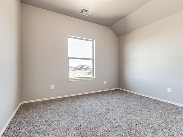 carpeted spare room featuring baseboards, visible vents, and vaulted ceiling