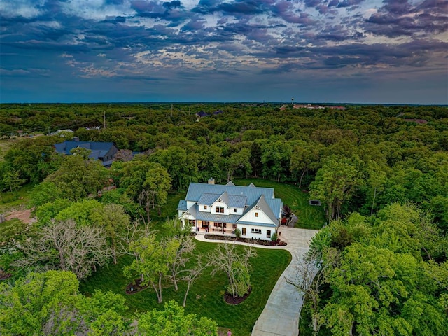 bird's eye view with a wooded view