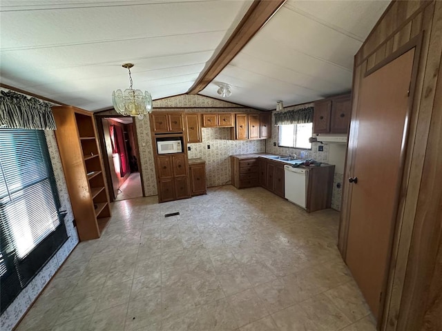 kitchen with lofted ceiling with beams, a chandelier, white appliances, a sink, and brown cabinetry