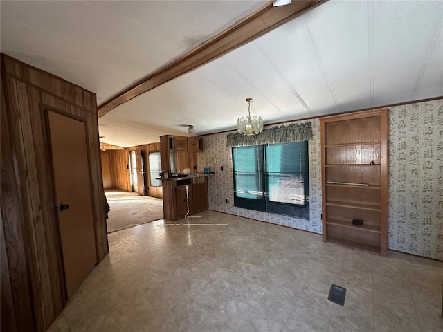 unfurnished dining area with beamed ceiling, light floors, and wallpapered walls