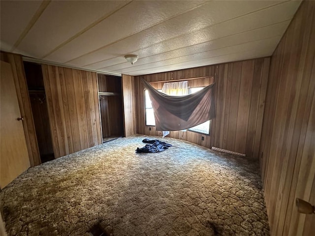 carpeted empty room with wooden walls