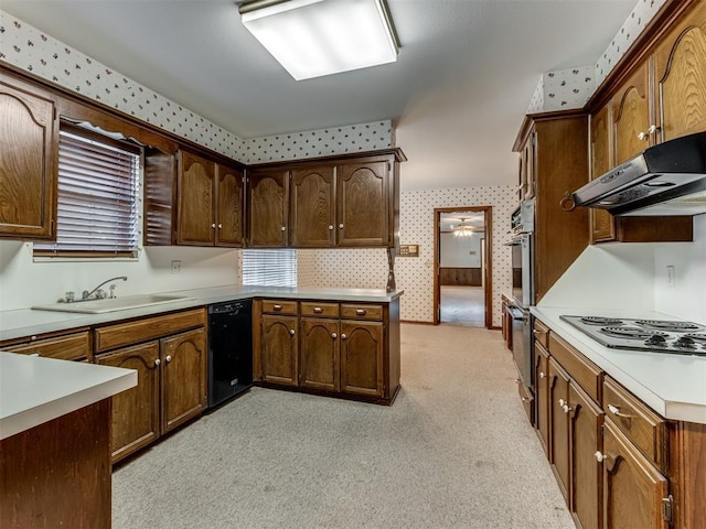 kitchen with wallpapered walls, black dishwasher, light countertops, under cabinet range hood, and a sink