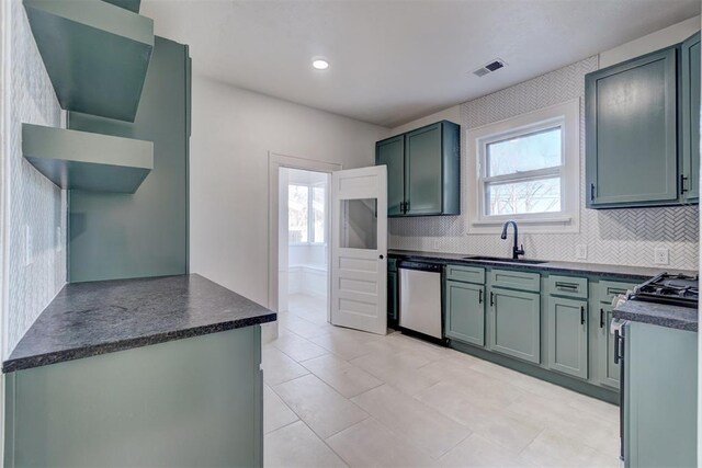 kitchen featuring dark countertops, visible vents, a sink, and stainless steel dishwasher