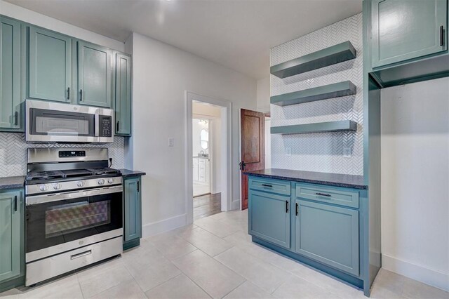 kitchen featuring tasteful backsplash, appliances with stainless steel finishes, open shelves, and light tile patterned flooring