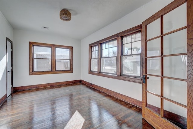 unfurnished room with visible vents, baseboards, and wood finished floors