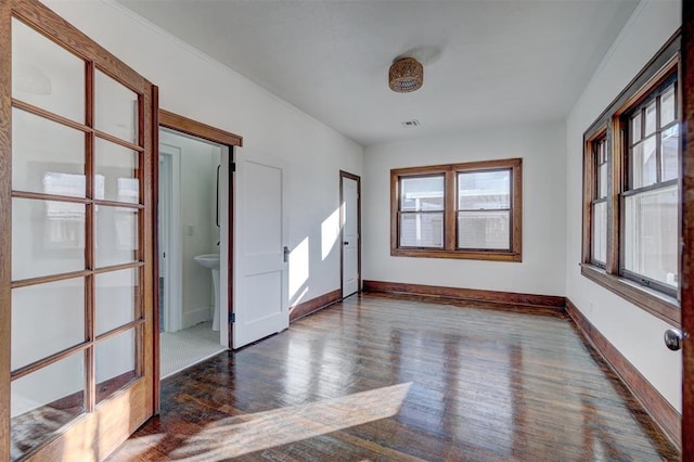 unfurnished room featuring visible vents, baseboards, and wood finished floors