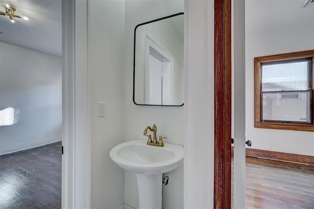 bathroom with visible vents, a sink, baseboards, and wood finished floors