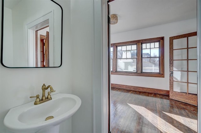 bathroom featuring a sink, baseboards, and hardwood / wood-style flooring