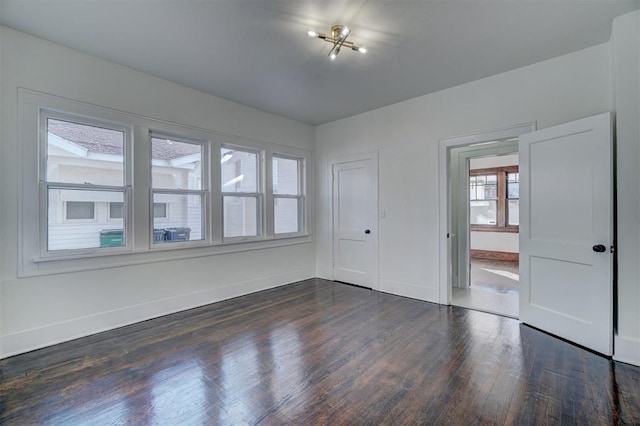 spare room featuring dark wood finished floors and baseboards