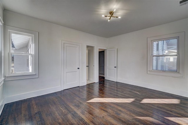 spare room with baseboards, visible vents, and wood finished floors