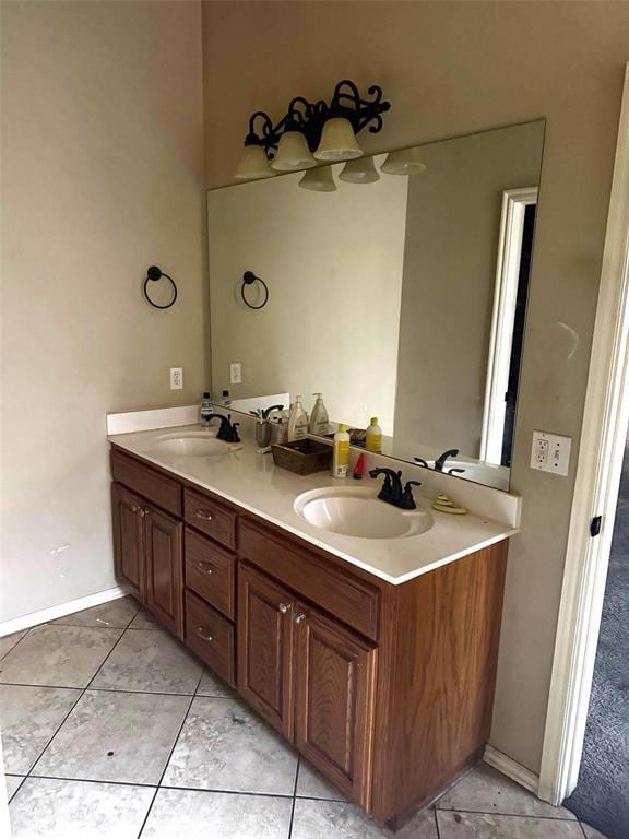 bathroom with a sink, baseboards, and double vanity