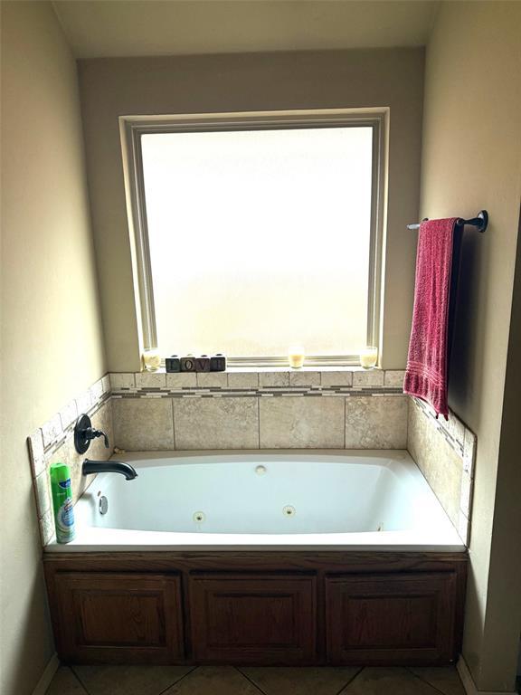 bathroom featuring a whirlpool tub, tile patterned floors, and a healthy amount of sunlight