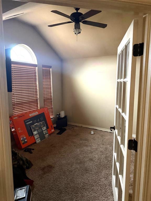 carpeted spare room featuring lofted ceiling and a ceiling fan