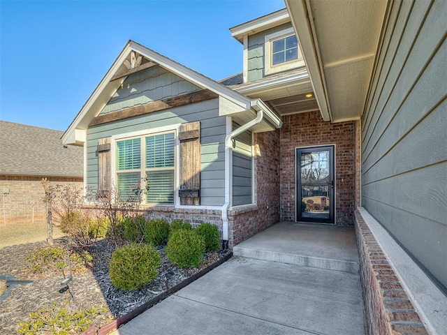 view of exterior entry featuring brick siding