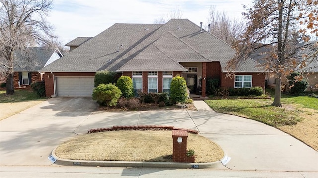 view of front facade with a front lawn, concrete driveway, brick siding, and an attached garage