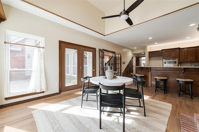 dining space featuring light wood-style flooring, ceiling fan, stairway, french doors, and recessed lighting