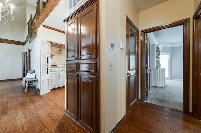 corridor featuring baseboards, ornamental molding, and dark wood-type flooring