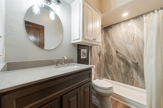 bathroom featuring toilet, curtained shower, and vanity