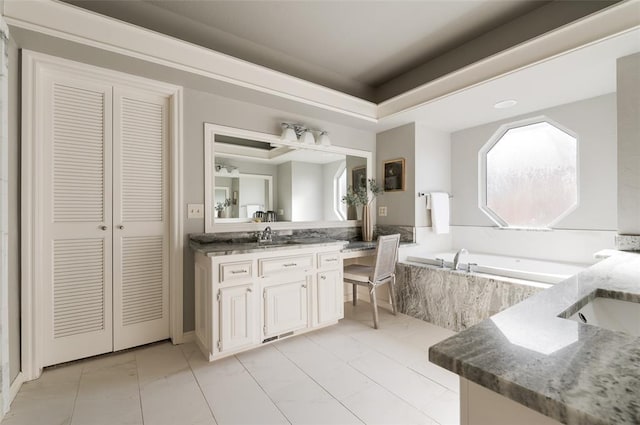 full bathroom featuring a garden tub, a raised ceiling, a closet, and vanity