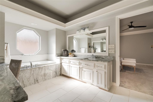 full bathroom with ceiling fan, ornamental molding, a garden tub, a tray ceiling, and vanity