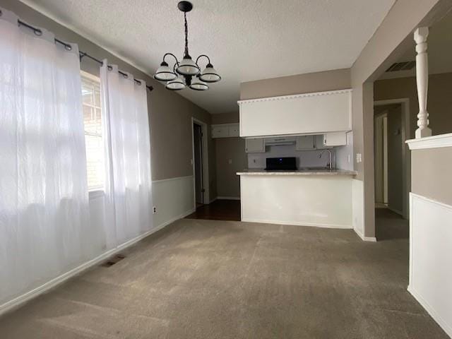 kitchen with visible vents, stove, dark carpet, and white cabinetry